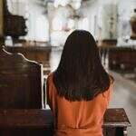 Like me, you may feel alone in this world. Image of a woman praying in a church.