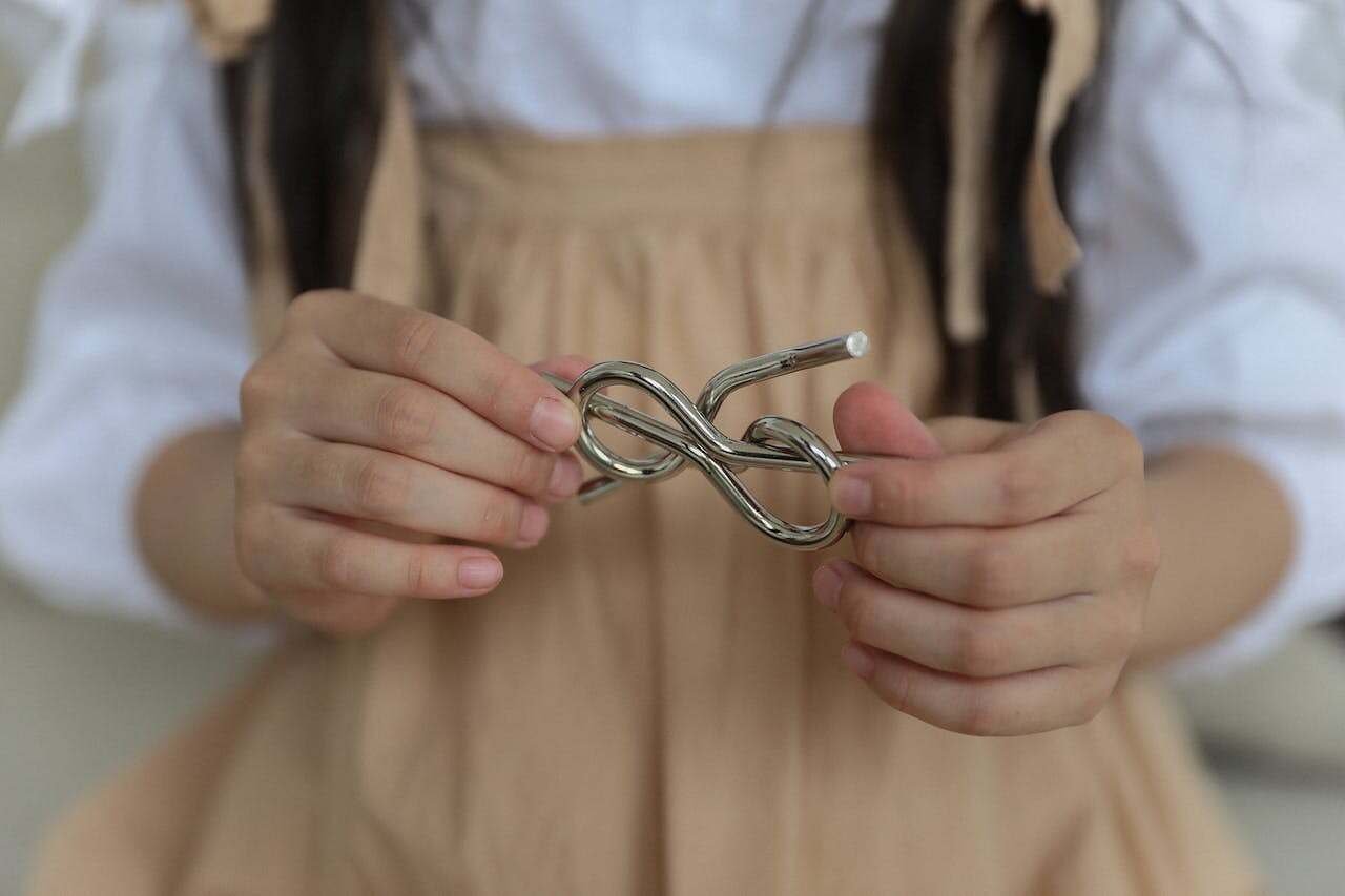 Problem solving photo Photo by Monstera Production: https://www.pexels.com/photo/crop-little-girl-holding-metal-knot-teaser-5063378/