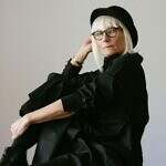 Image of an older woman dressed in black with a black hat and glasses.