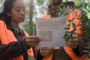 Curious about forensic mediumship? Image of two people wearing safety vests looking at a missing person's flyer.