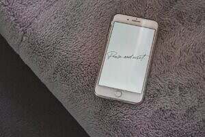 Image of a cell phone on a grey carpet with the words pause and reset written on the phone