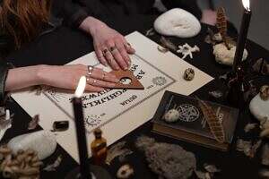 Image of a woman using an Ouija Board.