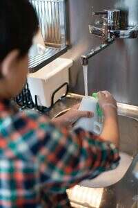 Child washing a dish.