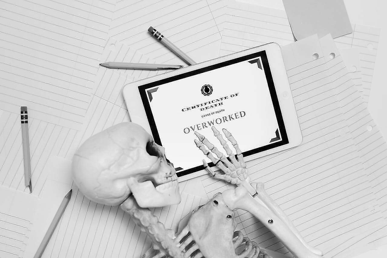Skeleton with death certificate to example work-life balance.