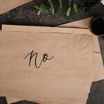 the importance of a "no" person in your life. Image of brown paper on a desk with the word no written in script.