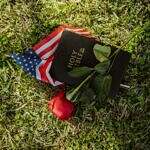 When faith is used as a weapon, it overwhelms me—and I imagine it overwhelms others too. Image of an American flag, holy bible and red rose laying on the ground.