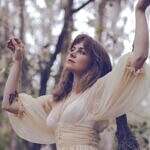 You Are Still Becoming. Image of a woman in a tree with a butterfly tattoo on her arm
