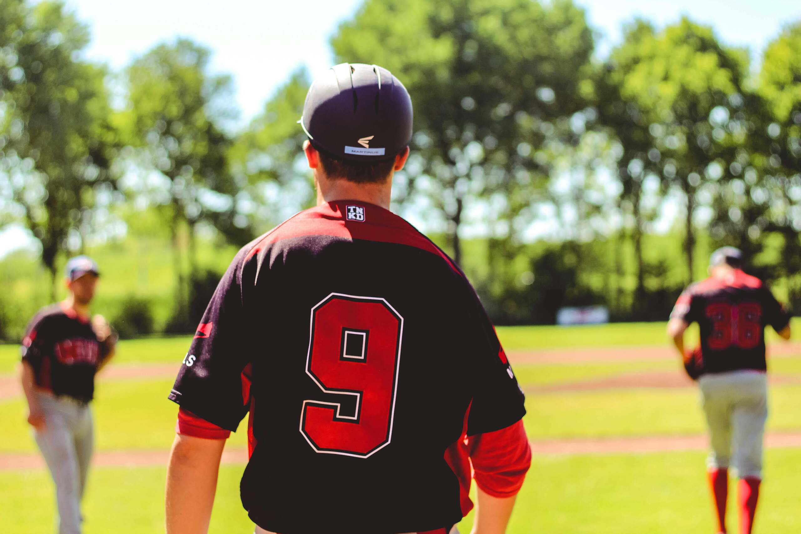 The nines in Tarot. Image of three baseball players one facing away where we see his number 9 on his jersey.