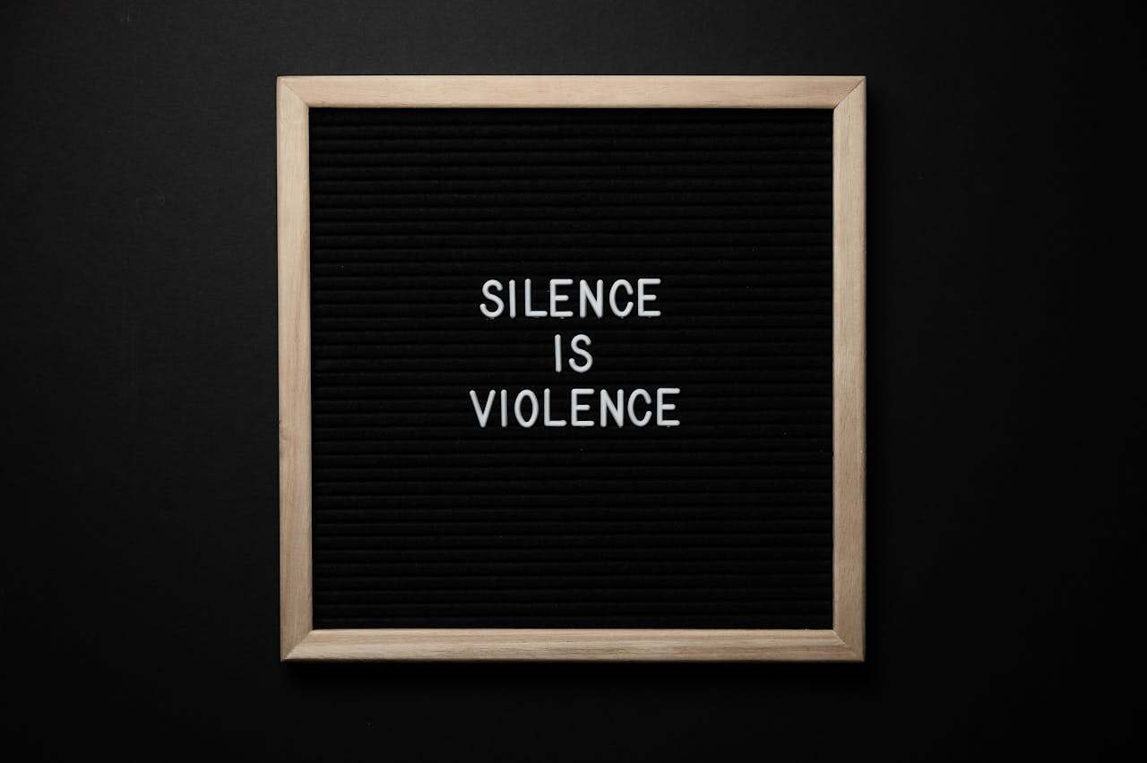 Image of a message board on black background with white letters saying silence is violence.