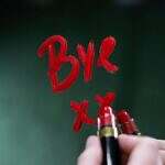 Image of a mirror with a person writing in red lipstick Bye xx. Represents losing people...