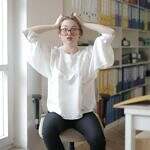 Not every spiritual teacher is meant to stay in our lives forever. Some—whether they realize it or not—show up to teach us what not to do. Image of a woman at a desk in front of a window looking stressed out