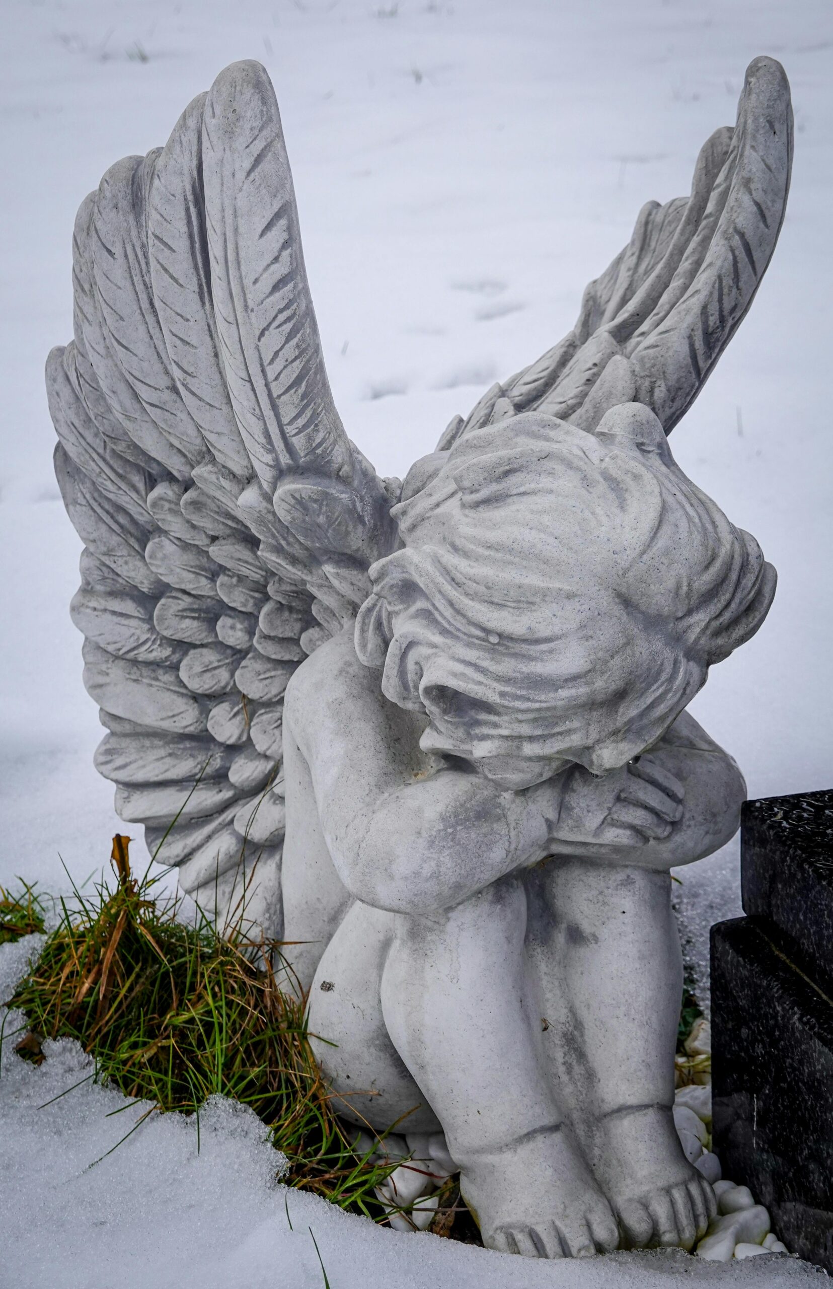 Image of an angel statue looking sad.
