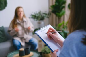 Image of a woman with a clipboard as another woman talks