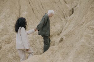 Image of an older woman leading a younger woman up a hill.