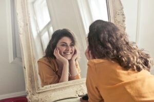 Image of a woman looking at herself in the mirror