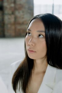 Image of a women dressed in white looking up.