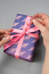 Image of a brightly colored purple box with a pink ribbon