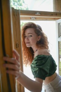 Image of a woman opening a door with sunlight behind her.