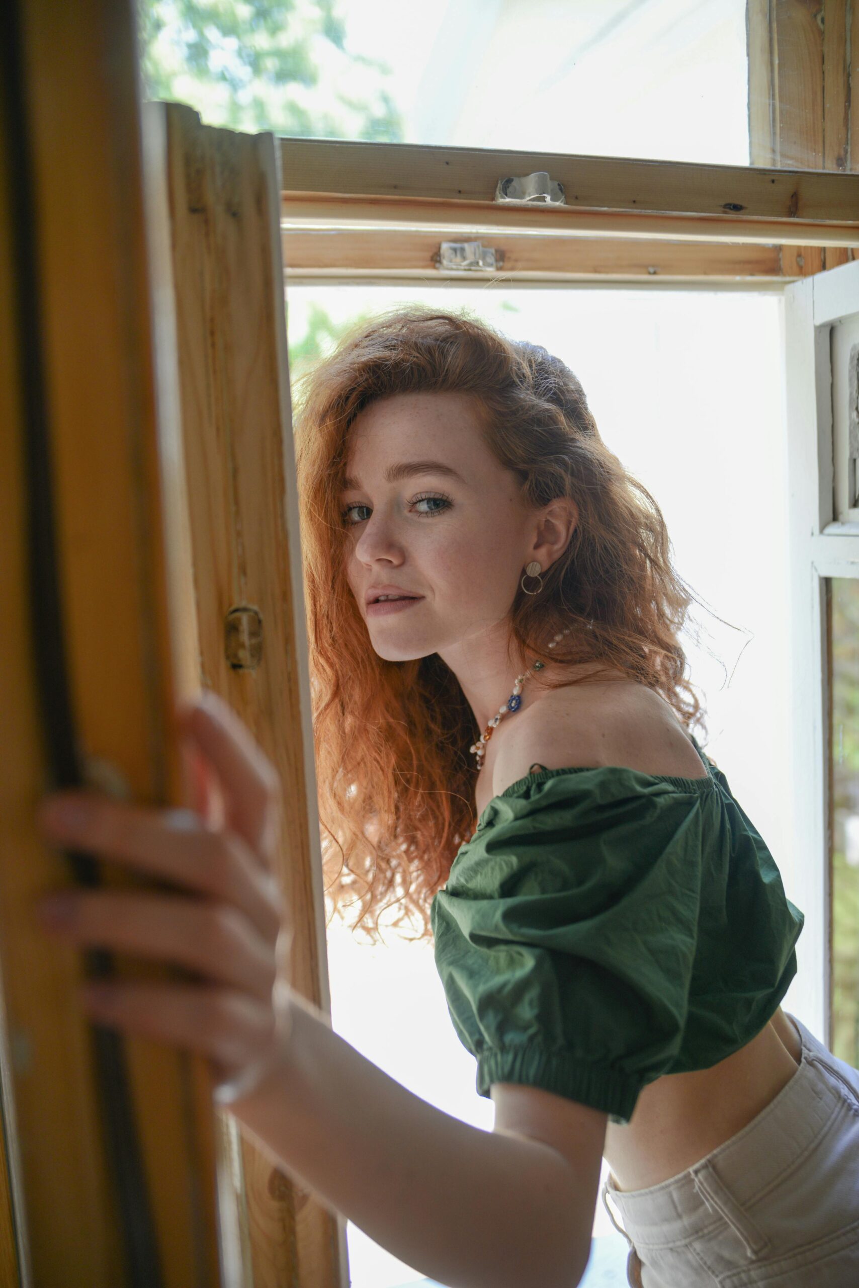 Image of a woman opening a door with sunlight behind her.