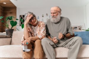 Image of a confused couple sitting on a couch