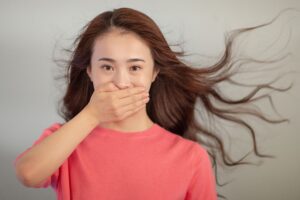 Image of a woman covering her mouth to stop her from saying something.