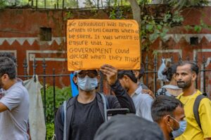 Image of a group of protesters one holding a sign.