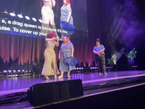Image of Colleen Irwin center stage with Lucy Darling and another member of the audience.