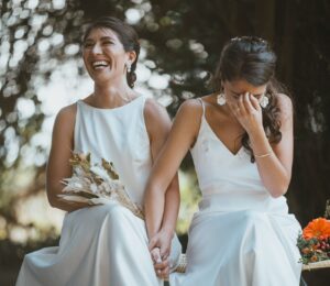 Image of a wedding couple holding hands laughing.