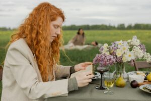 Image of a woman sitting at a picnic bench alone.