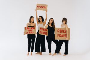 Image of a group of women holding up banners about sexism.